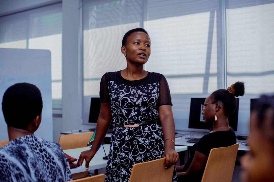 Professional presenting sustainability ideas on stage at the U.S. Embassy Tanzania during a Circular Economy Fellowship event