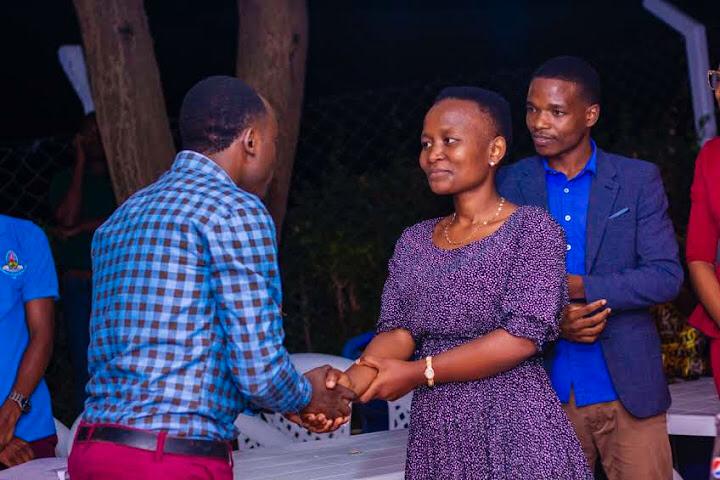 A professional handshake between the new leader and the former leader during an official leadership transition ceremony.