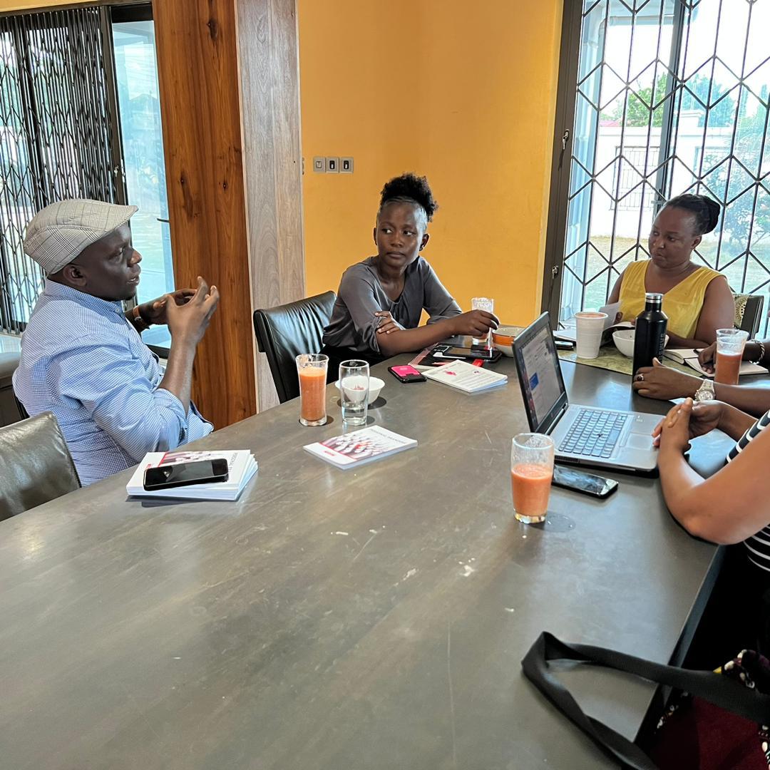 A group of professionals engaged in an active, focused discussion around a table during a strategic planning meeting