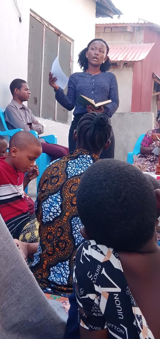 A researcher actively taking down notes and interviewing community members during a sociological field study.