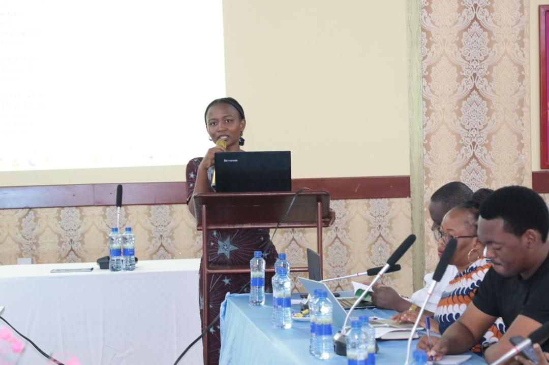 A young professional delivering a presentation on Laudato Si' environmental strategies to a conference hall of AMECEA delegates at the Tanzania Episcopal Conference headquarters.