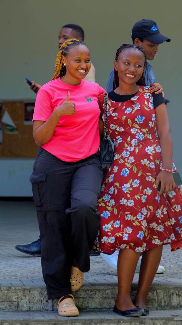 Two climate advocates, including Laurel Kivuyo, standing side-by-side and smiling confidently at a regional sustainability conference.